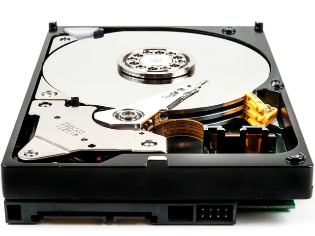 An open 3.5 inch hard drive with its platter and actuator arm visible